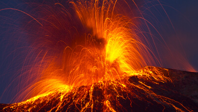 erupting valcano shooting lava, debris, gas and more into the air. 